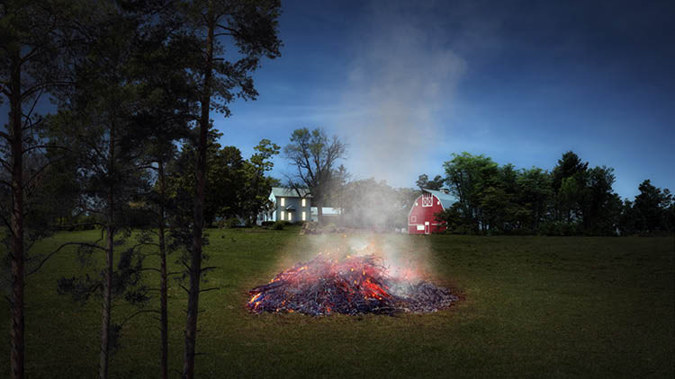 Burn pile near a house at dusk